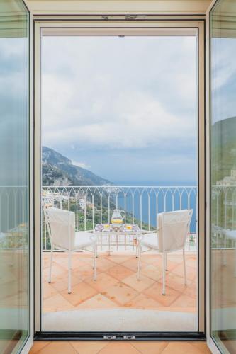 a view from the balcony of a house with a table and chairs at Five Positano in Positano