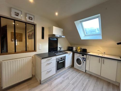 une cuisine avec un évier et une cuisinière four supérieur dans l'établissement La Cabane de la Rance - appartement 3 personnes, à Lanvallay