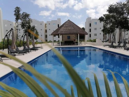 普拉亚卡门Departamento Itzae的一个带椅子和凉亭的大型游泳池