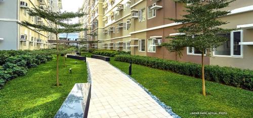 una pasarela frente a un edificio con árboles en 2BR Fully Furnished Unit at Fairview QC, en Manila