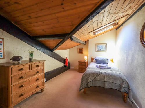 a bedroom with a bed and a wooden ceiling at Courtyard Cottage in Ambleside
