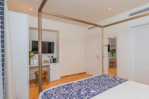 a bedroom with a canopy bed and a kitchen at Five Positano in Positano