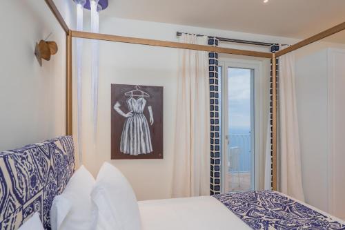 a bedroom with a bed and a dress on the wall at Five Positano in Positano