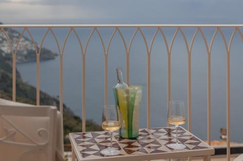 a table with two glasses and a bottle of wine at Five Positano in Positano