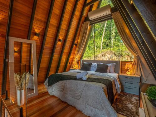 ein Schlafzimmer mit einem Bett in einem Baumhaus in der Unterkunft Cabana Memórias in Gramado