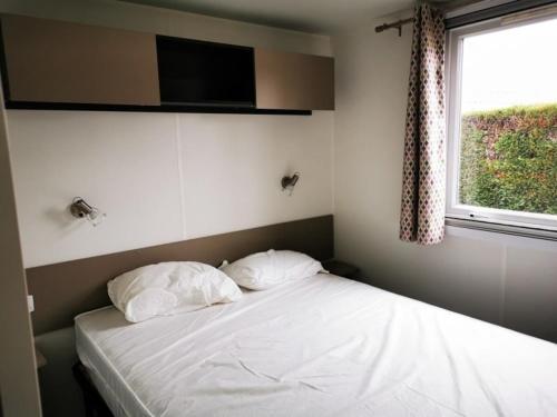 - une chambre avec un lit avec deux oreillers et une fenêtre dans l'établissement Les Charmettes 4 étoiles emplacement 429 3CH 2SDB 8 pers, aux Mathes