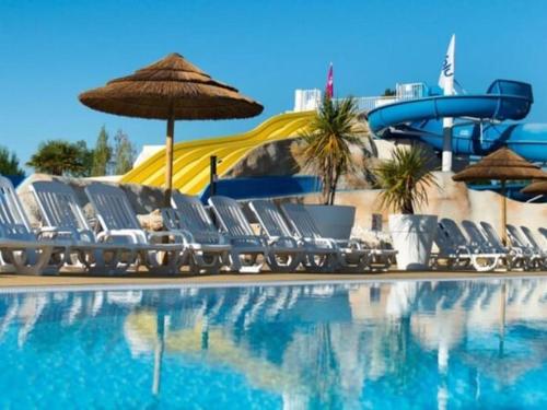 - une piscine avec des chaises et un toboggan dans l'établissement Les Charmettes 4 étoiles emplacement 429 3CH 2SDB 8 pers, aux Mathes