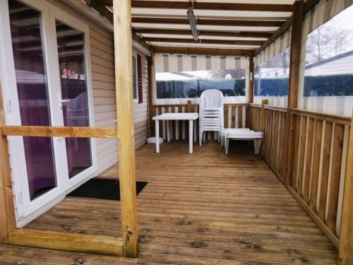 - une terrasse couverte avec 2 chaises et une table dans l'établissement Les Charmettes 4 étoiles emplacement 429 3CH 2SDB 8 pers, aux Mathes