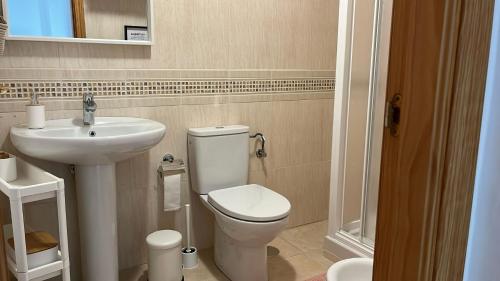 a bathroom with a white toilet and a sink at La Tahona in Nerja