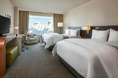 a hotel room with two beds and a television at The Westin Denver International Airport in Denver