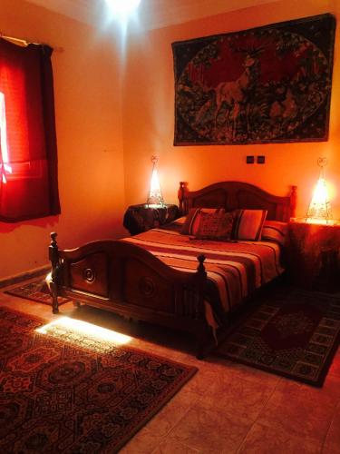 a bedroom with a large wooden bed with two lamps at Chez Fouzia in Essaouira