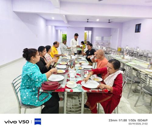 a group of people sitting at a table eating food at Hotel Golden Buddha Inn Bodhgaya in Bodh Gaya