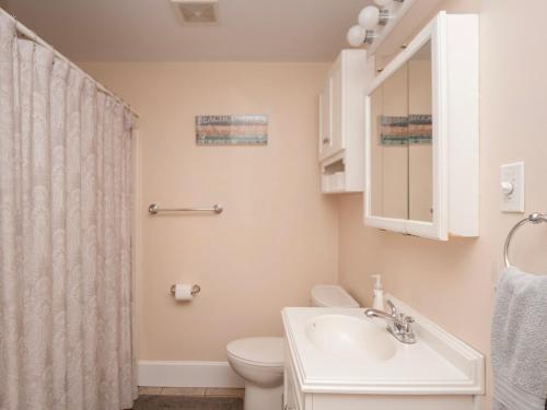 a bathroom with a sink and a toilet and a mirror at Open Concept Beach House in Middletown