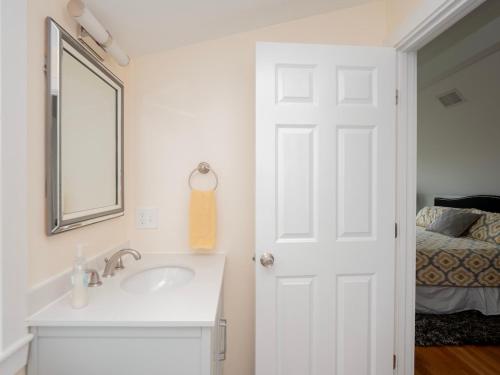 a bathroom with a sink and a mirror and a bed at Open Concept Beach House in Middletown