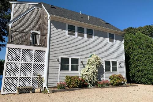 a white house with a large door and flowers at Open Concept Beach House in Middletown