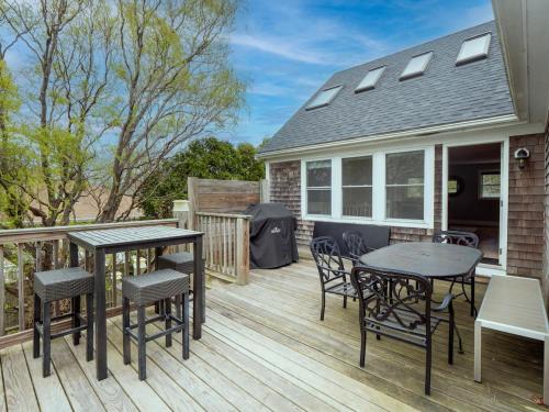 a deck with tables and chairs and a house at Open Concept Beach House in Middletown