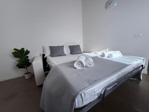 a white bedroom with a large bed with towels on it at GOMES COMFORT HOUSE in Valeggio sul Mincio
