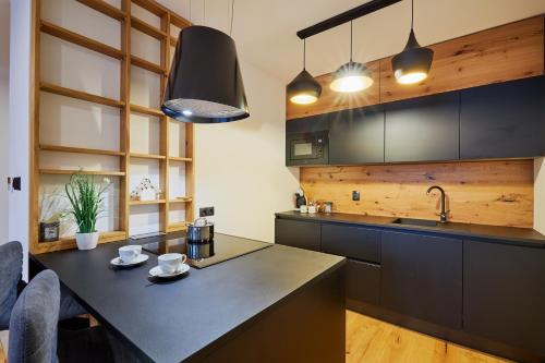 a kitchen with a black counter top and wooden cabinets at RV Apartment Smaragd in Smokovce