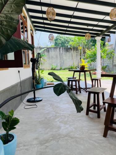 a patio with a table and chairs and plants at Villa Hideout in Weligama