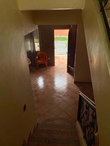 a hallway with a staircase and a red chair at B&b stella maroco in Sidi Bouzid