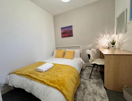 a bedroom with a bed with a yellow blanket on it at Room 5 Shared House in L6 in Liverpool