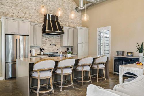 a kitchen with white cabinets and a bar with stools at Lazy River Ranch - Lazy River Pool, Golf & Pickleball in Kreutzberg