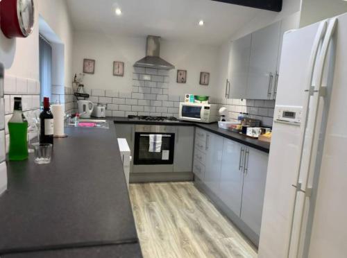 a kitchen with white appliances and a black counter top at Room 5 Shared House in L6 in Liverpool