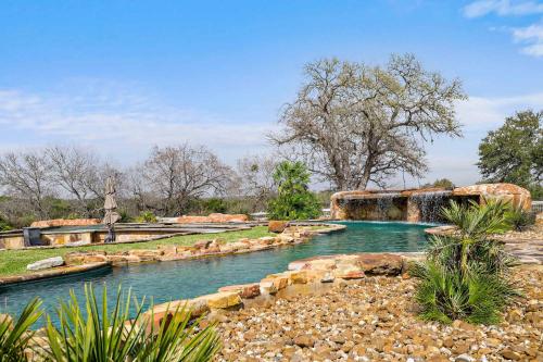 a river with a waterfall in a park at Lazy River Ranch - Lazy River Pool, Golf & Pickleball in Kreutzberg