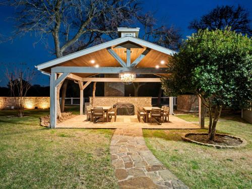 a pavilion with tables and chairs in a yard at night at Lazy River Ranch - Lazy River Pool, Golf & Pickleball in Kreutzberg