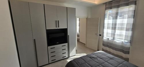 a bedroom with a bed and a television in a cabinet at Golden Moon in Lido di Ostia