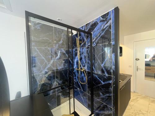 Cette chambre est dotée d'un mur recouvert de marbre bleu. dans l'établissement Studio Naturiste WILD Heliopolis F 96, au Cap d'Agde