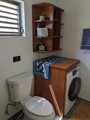a bathroom with a toilet and a washing machine at Brand New! Black Sand Beach-Casa NoSe' in Vieques