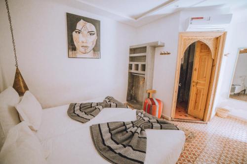 a bedroom with a bed and a picture of a woman at Riad Le Petit Joyau in Marrakech