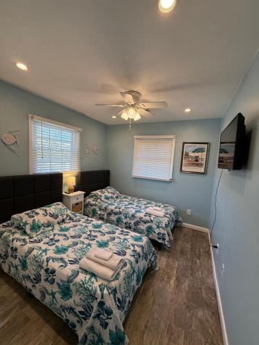 a bedroom with two beds and a ceiling fan at Endless Beach #B,Oceanfront, 3bedrooms-2bath-Pet Friendly in Virginia Beach