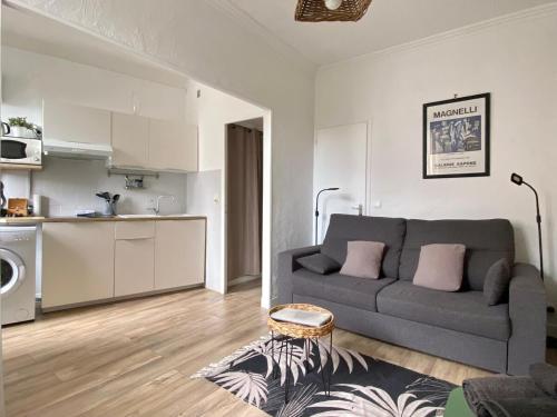 un salon avec un canapé et une cuisine dans l'établissement Cannes Studio - 12F, à Cannes