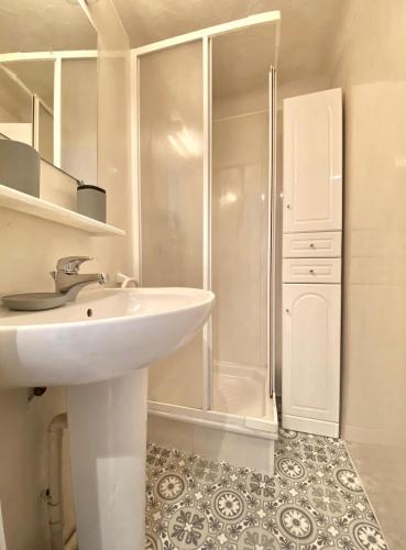 une salle de bain blanche avec un lavabo et une douche dans l'établissement Cannes Studio - 12F, à Cannes