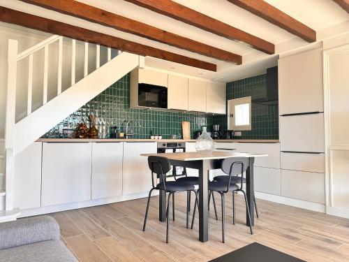 une cuisine avec des armoires blanches et une table et des chaises dans l'établissement Domaine de Kernizan, à Plouharnel