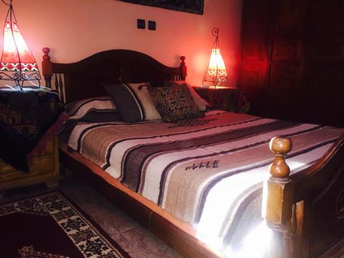 a bedroom with a bed with two lamps on it at Chez Fouzia in Essaouira
