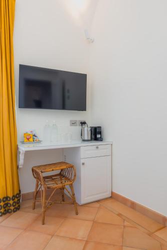 a room with a desk with a tv and a chair at Five Positano in Positano