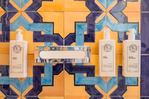 a group of four shampoo bottles on a tile wall at Five Positano in Positano