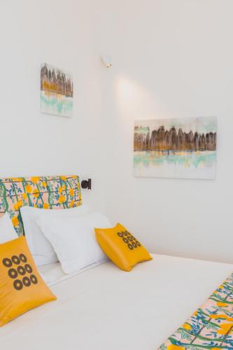 a bed with yellow and white pillows on it at Five Positano in Positano