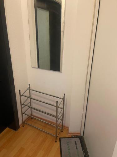 a mirror on a wall with a metal rack in a room at Mano 31 in Stuttgart