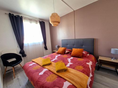 une chambre avec un grand lit avec des oreillers orange dans l'établissement Le Chap'Appart, T3, à Narbonne