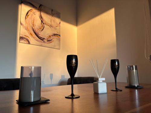 three wine glasses sitting on a wooden table at Wood&Stone - Modernes Haus in Seenähe am Tankumsee mit Terrasse, Outdoorküche, Kamin, Homeoffice Bereich & voll ausgestatteter Küche im Naherholungsgebiet in Isenbüttel