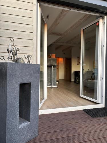 a living room with a large stone fireplace on a house at Wood&Stone - Modernes Haus in Seenähe am Tankumsee mit Terrasse, Outdoorküche, Kamin, Homeoffice Bereich & voll ausgestatteter Küche im Naherholungsgebiet in Isenbüttel