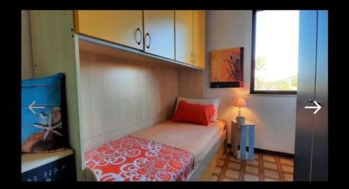 Un dormitorio pequeño con una cama y una ventana. en Appartamento LUCAS, en Stintino