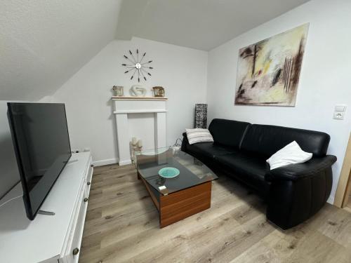 a living room with a black couch and a tv at Friedrich Neunzehn in Andernach