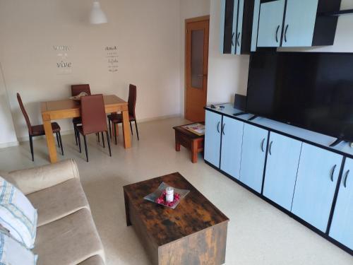 a living room with a large television and a table at La Dehesa in Torrox