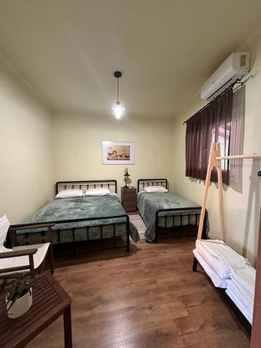 a room with two beds and a table at Village House Kalypso in Paleokastritsa