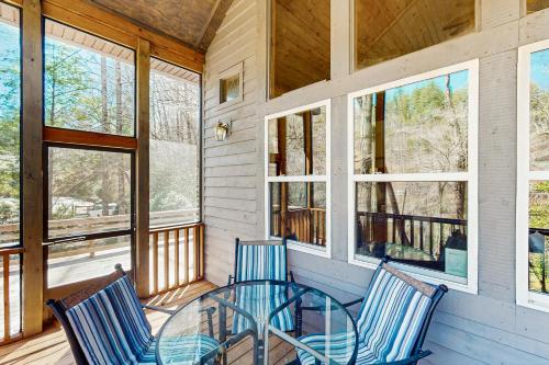 a screened porch with two chairs and a glass table at Toccoa Hideaway in Aska